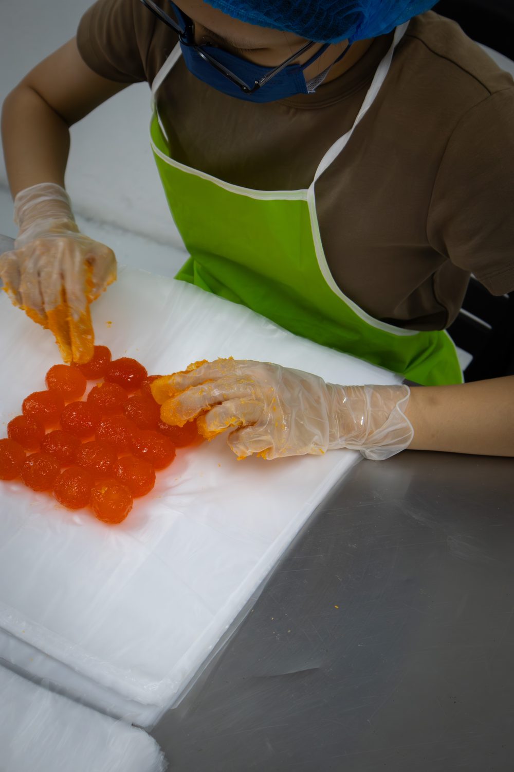 Hands grading freshly separated salted egg yolks